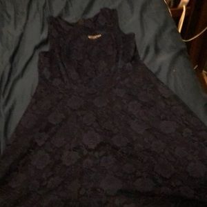 Dark blue dress with blue rose designs on it goes about to the knee